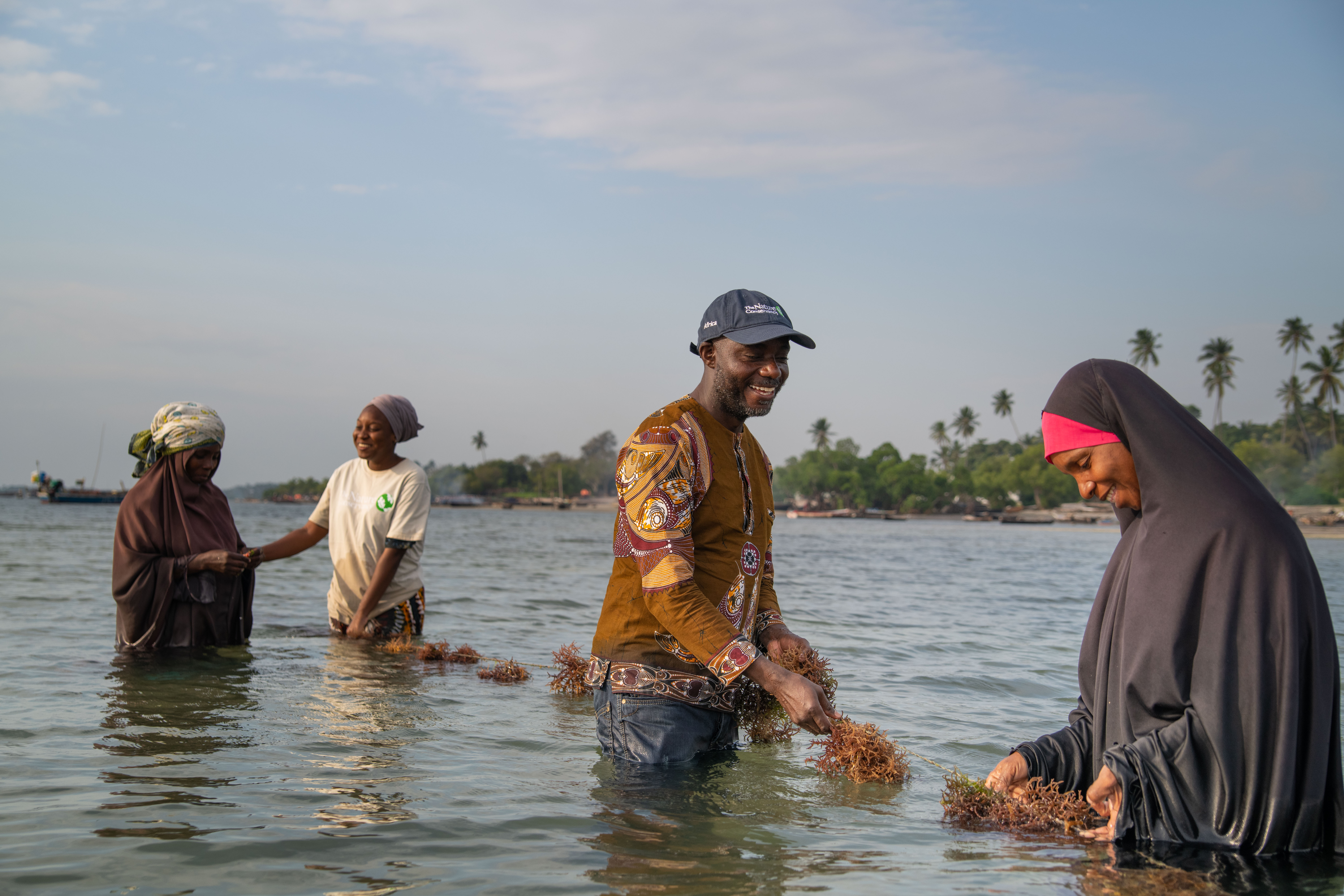 Trainers and local seaweed farmers, Bi Kombo Rashidi Ali and Time Asaka Kasim, stand in the water at the Tumbe seaweed pilot site in Pemba, Tanzania.